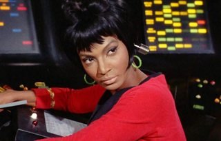 Uhura wearing a wireless earbud at one of the ship's consoles