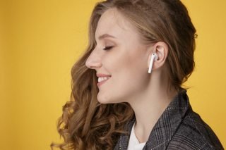 A promotional image of a woman with an AirPod in her ear